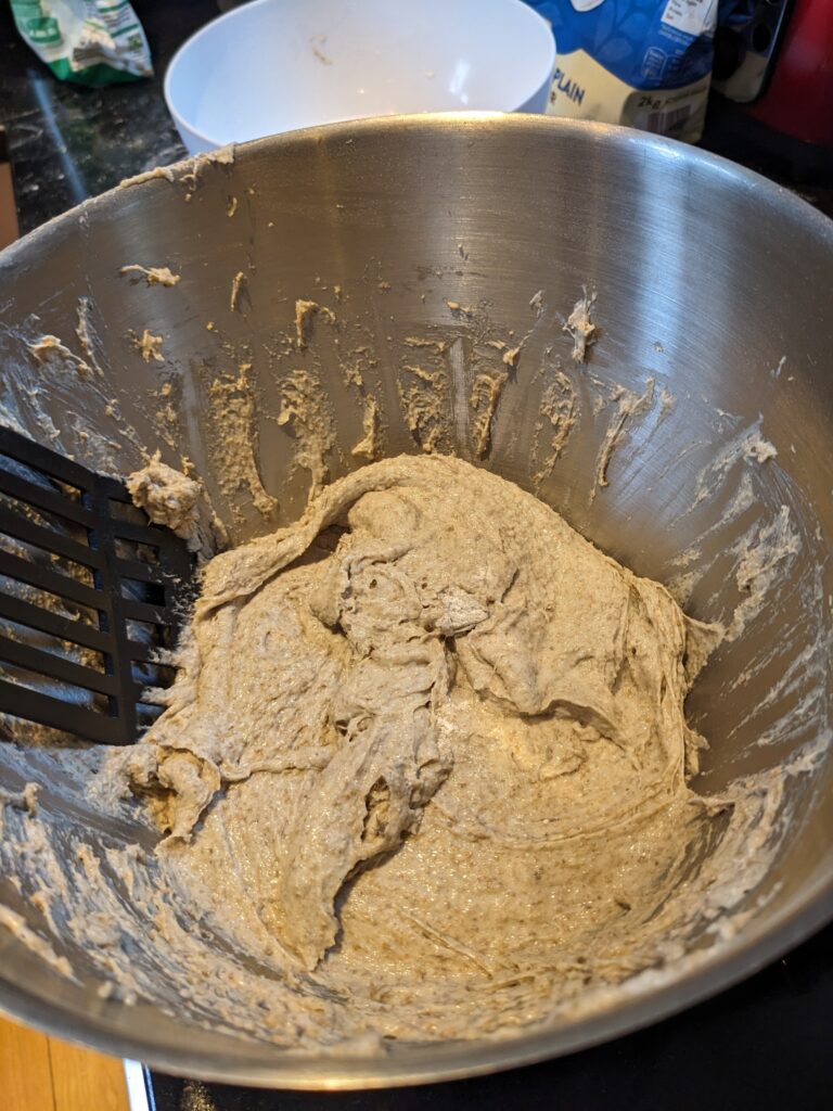 Wet rye dough in a steel mixing bowl.