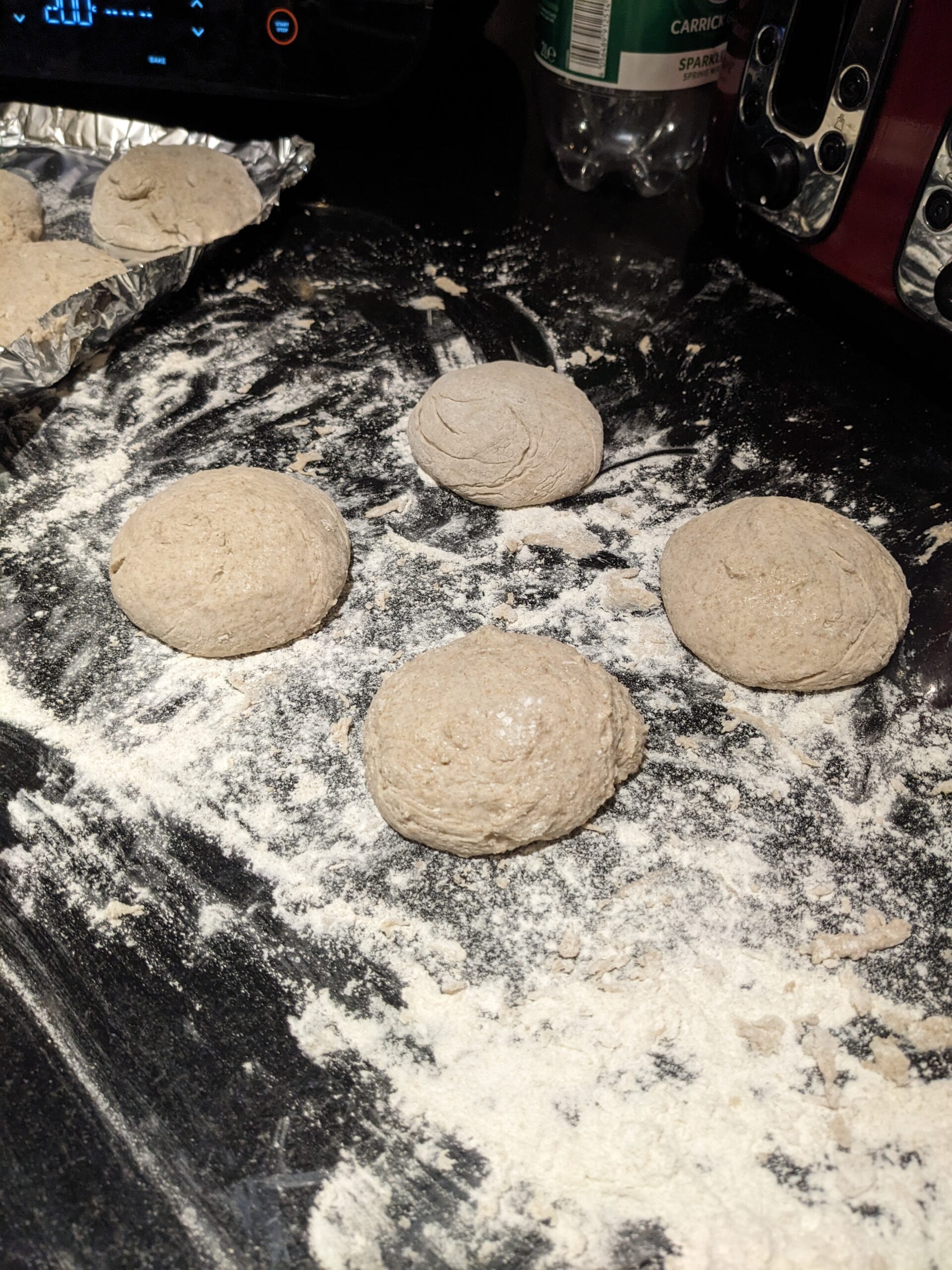 Image of four shaped rolls on a well floured counter-top, ready to go in the oven.